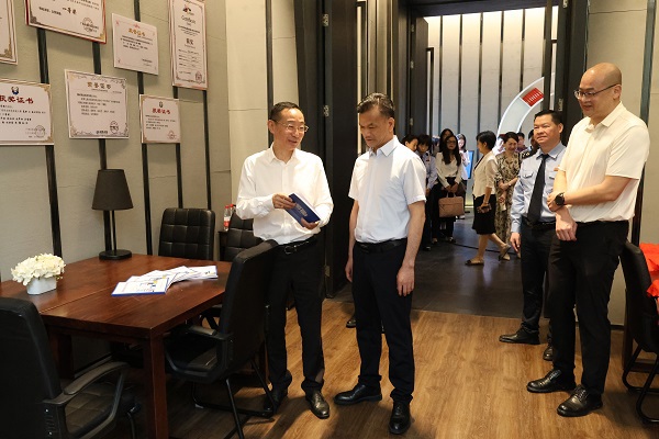 黄尚书（左二）、刘子林（左一）在税收普法教育研究室翻阅税法知识读本