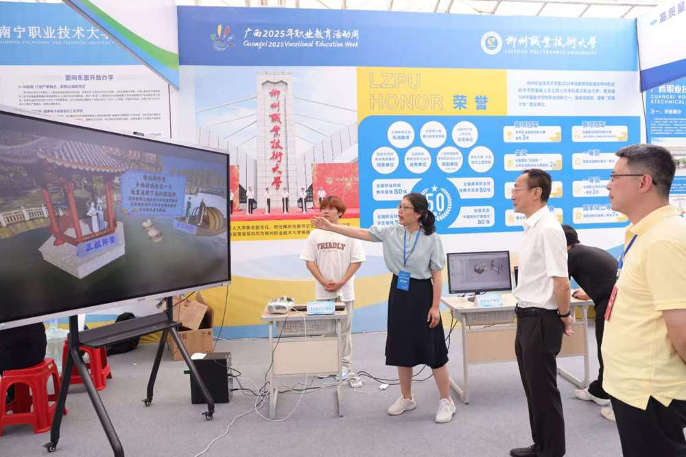 我校教师向党委书记刘子林介绍壮族非遗文化VR新体验项目