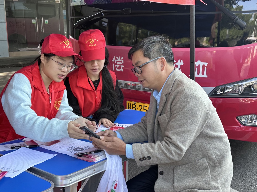 志愿者耐心为对献血有疑惑的师生讲解