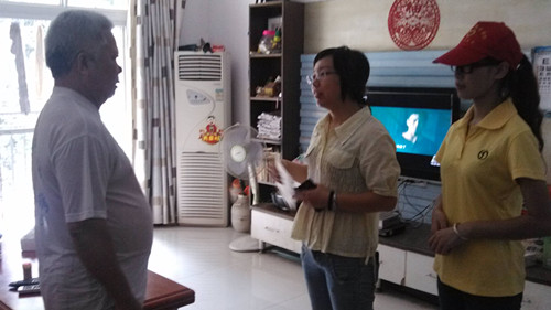 社区工作人员、志愿者与黄义彰老人交谈